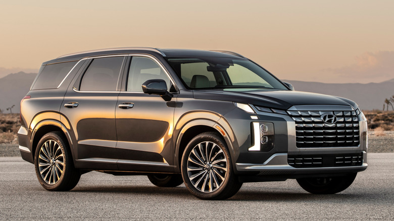 Side view of a 2025 Hyundai Palisade parked on a road with mountains in the background
