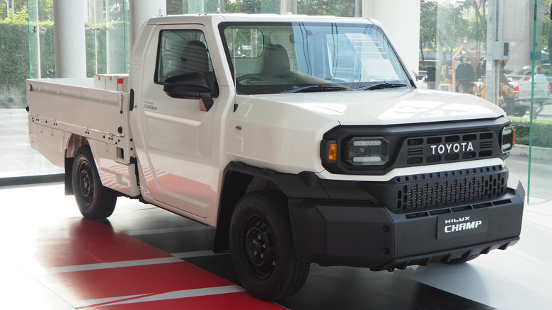 A Toyota Hilux Champ pickup inside a dealership, front 3/4 view