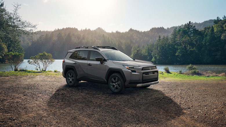 The new 2026 Toyota RAV4 in the Woodland trim level next to a lake, front 3/4 view