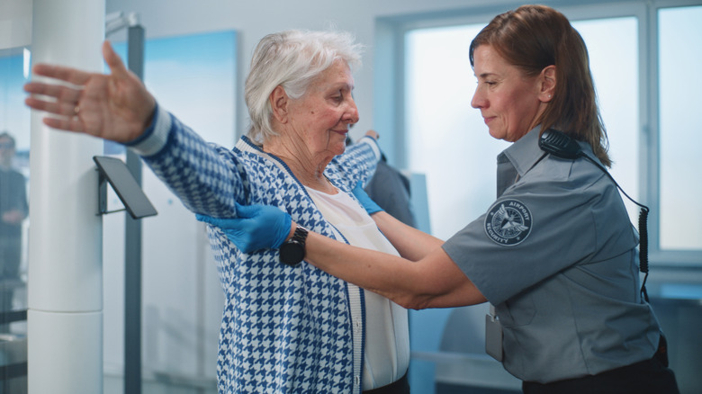 An airport security agent checking a passenger at an airport