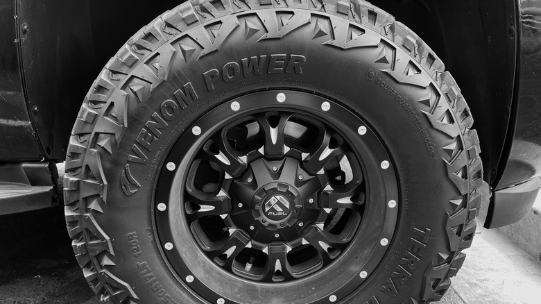 Closeup of a Venom Power tire with black custom rims