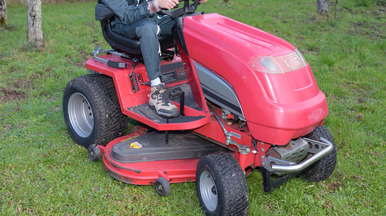 A man sitting on a riding lawn mower
