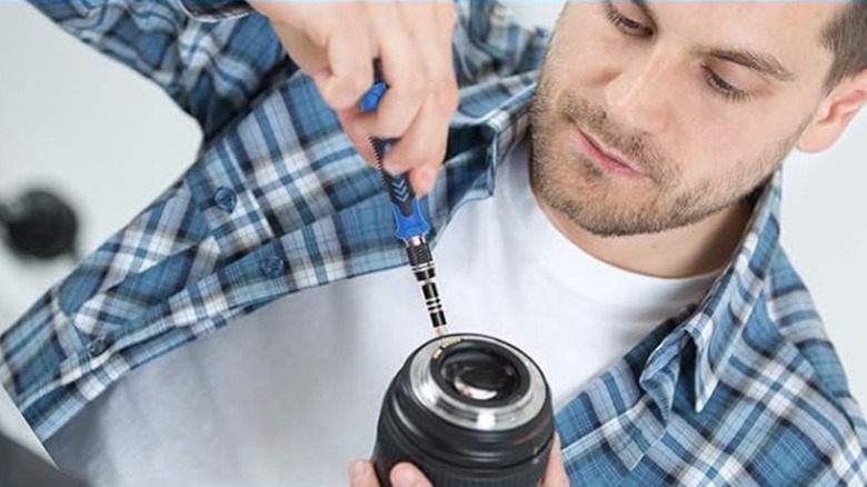 Person using Strebito tool on a camera lens