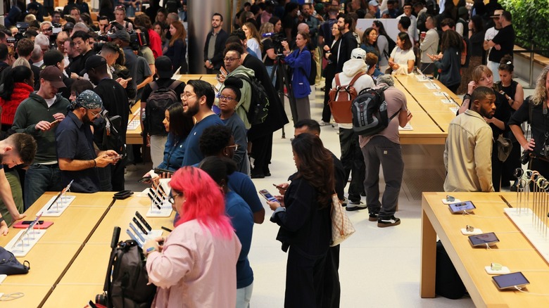 Huge crowd of people browsing and shopping iPhones at Apple Store