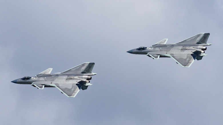 Two J-20s flying side by side against a blue sky