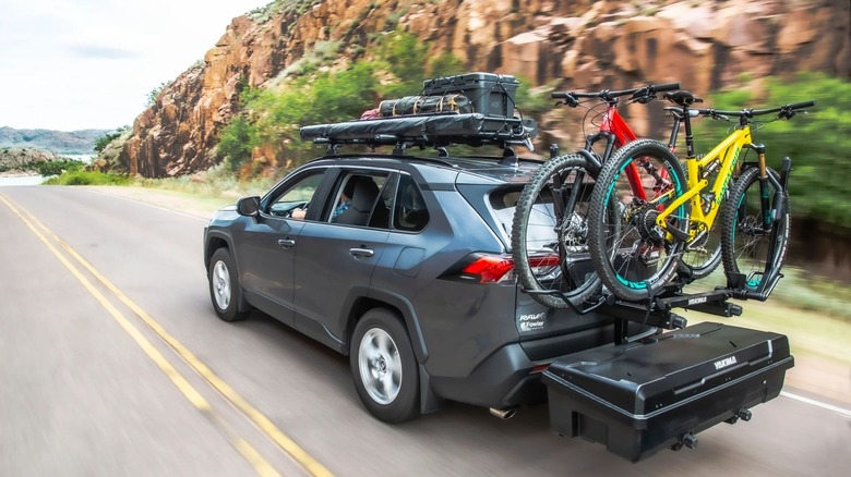 The Yakima Exo Rear Mounted cargo system mounted on a car, which is holding two bikes and other equipment