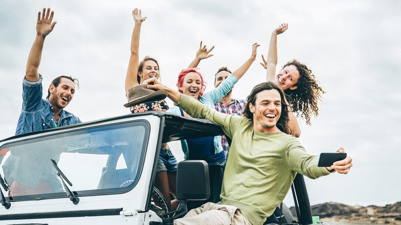Group of friends partying in a soft top jeep