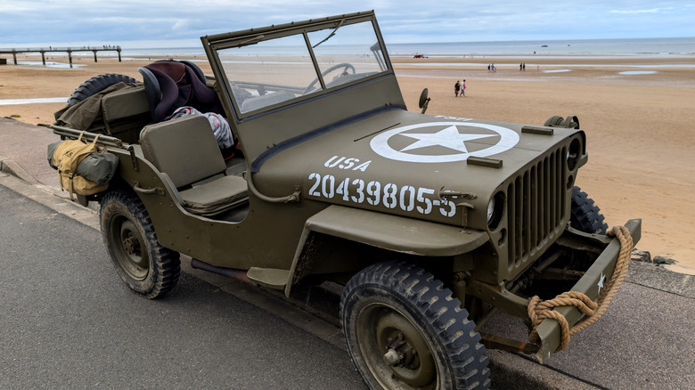 A restored Willys MB parked on a beach.