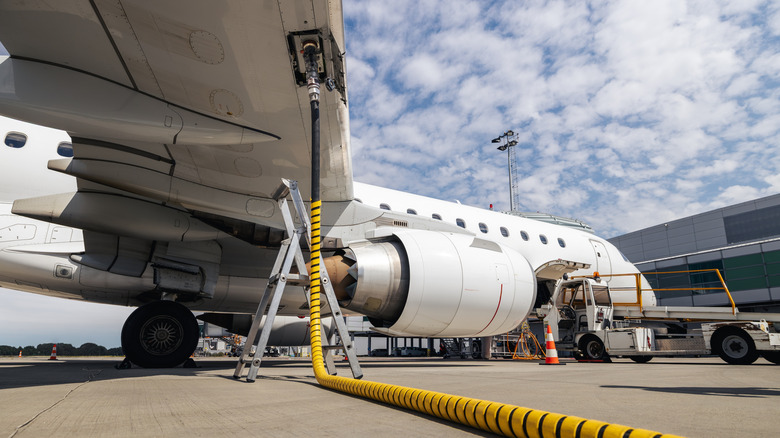 Passenger jet being refueled at an airport.
