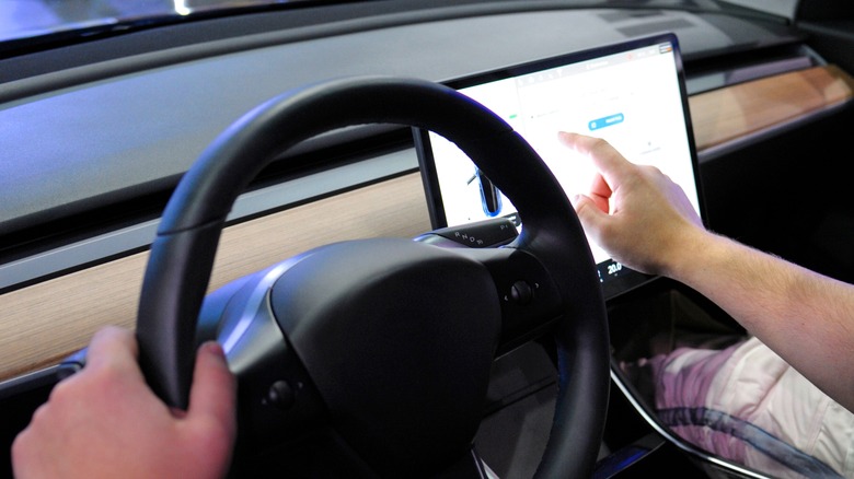 man touching tesla screen