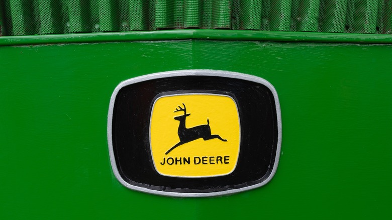 The John Deere logo  in black and gold on a green restored John Deere 3130.