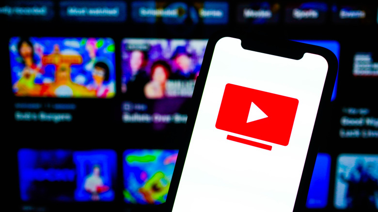 YouTube TV logo on phone with a TV in background