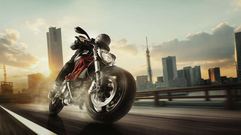 Helmeted motorcycle rider on hazy city road