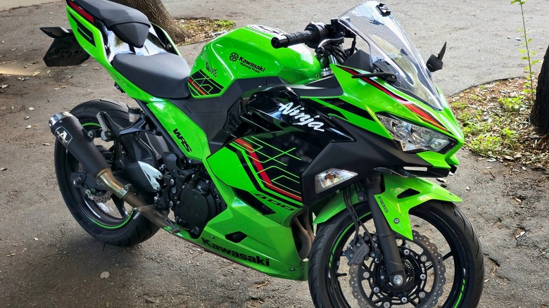 A lime green Kawasaki Ninja 400 parked near grass
