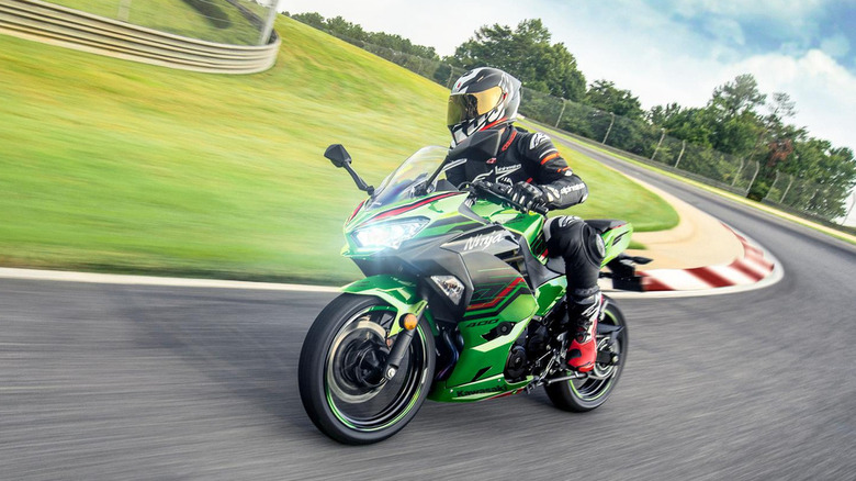 Green Kawasaki Ninja 400 turning into a corner on the track