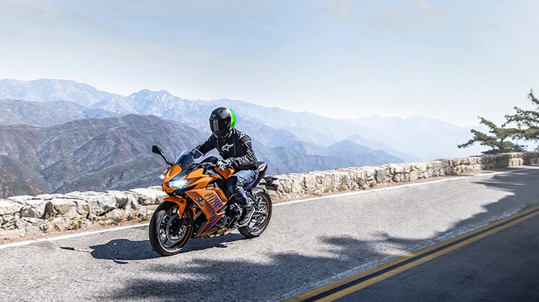 Orange Kawasaki Ninja 650 riding along the mountains
