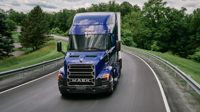 A blue Mack Anthem on the move, front 3/4 view