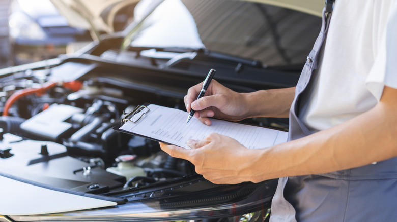 A person running through checklist for warranty at shop