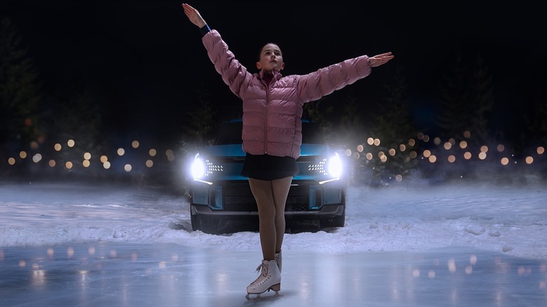 Young girl figure skating with EV9 in background