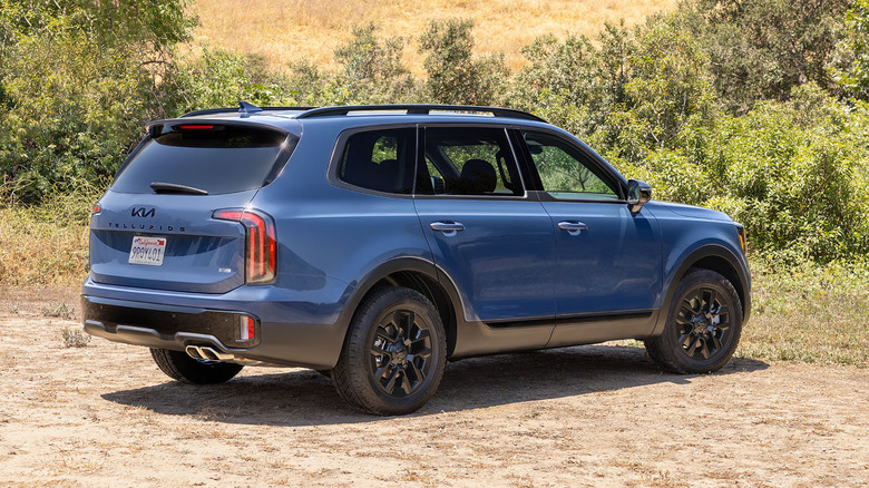 Rear 3/4 view of 2025 Kia Telluride in blue, black wheels
