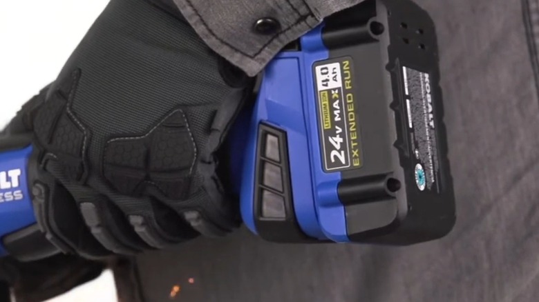 A person using a Kobalt battery to power a Kobalt tool.