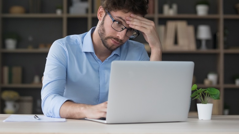 Person frustrated using laptop