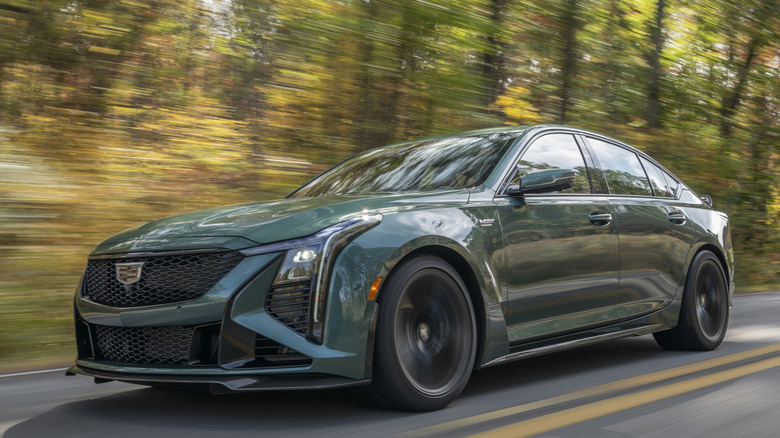 A front 3/4 view of Cadillac CT5-V Blackwing driving on the road in a forested setting