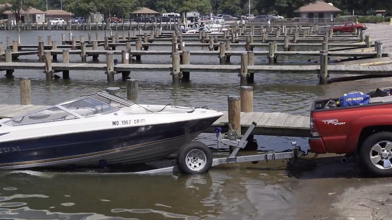 A Toyota pickup unloads a boat in water