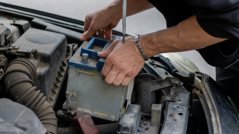 A driver replacing a car battery