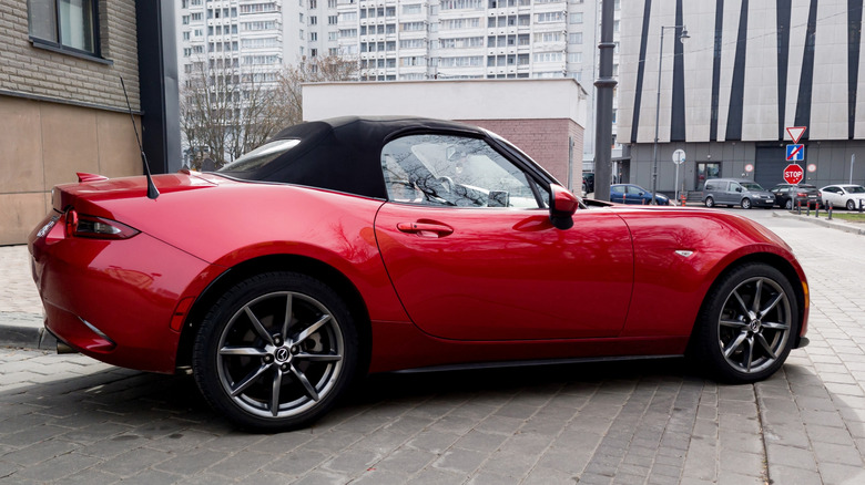 Side view of a red Mazda MX-5 Miata parked on a street