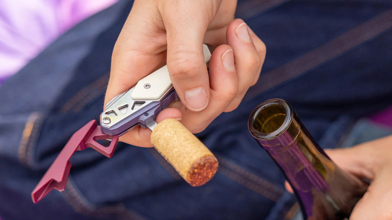Person using Leatherman's Picnic multi-tool to open a wine bottle.