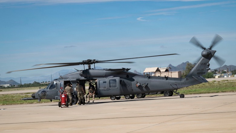 Personnel working on a U.S. Air Force HH-60W Jolly Green II helicopter
