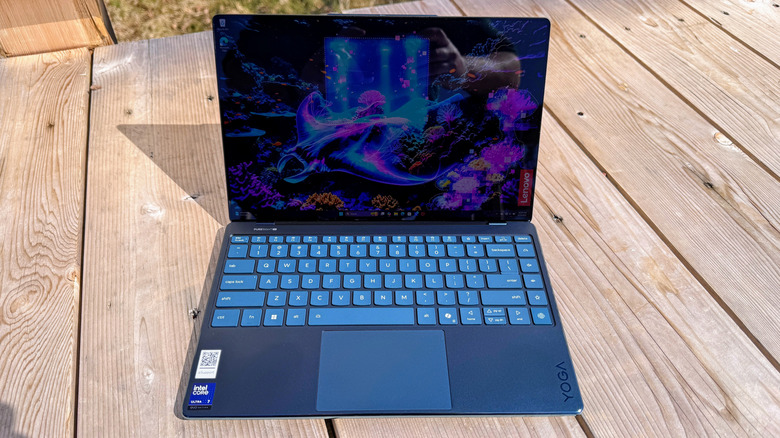 The Lenovo Yoga Slim 9i 14 Gen 10 on a light-colored wooden deck.
