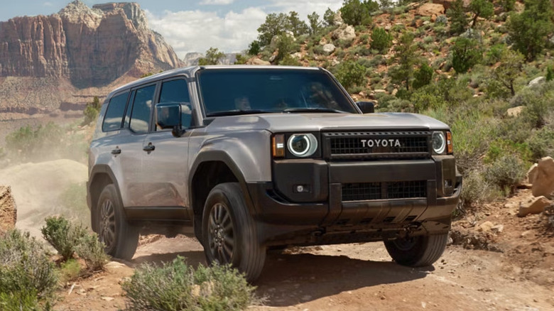 Front 3/view of blue Toyota Land Cruiser being driven on dirt road