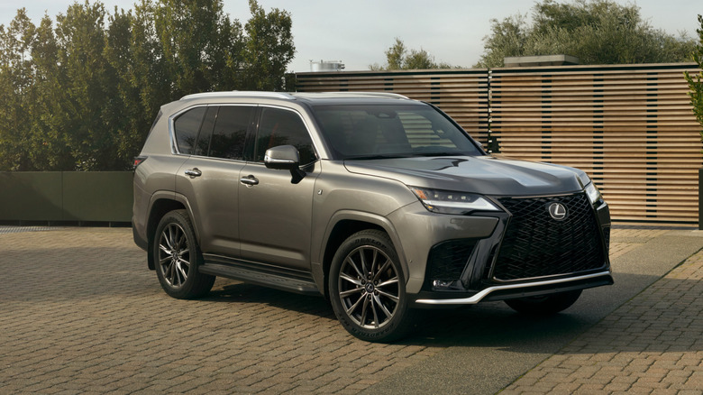 Silver Lexus LX 700h F Sport parked in front of a building