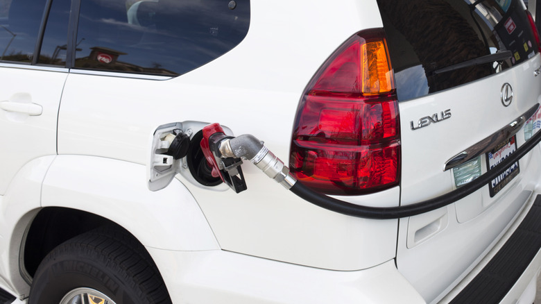 White Lexus car at gas pump