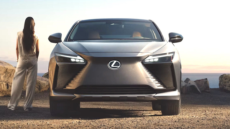 Person standing next to a parked Lexus