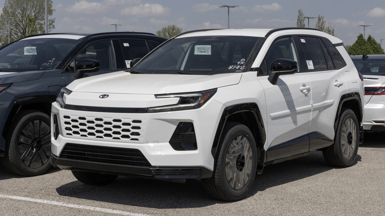 White 2026 Toyota RAV4 in a dealership parking lot.
