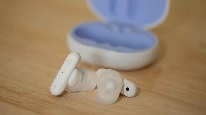 Logitech earbuds on wooden background