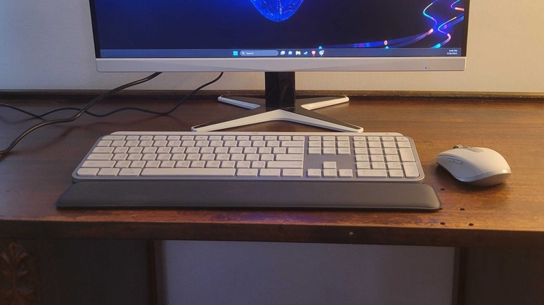 MX Keys S em uma mesa com um monitor