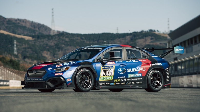 Front 3/4 view of 2026 Subaru WRX STI race car parked on race track.