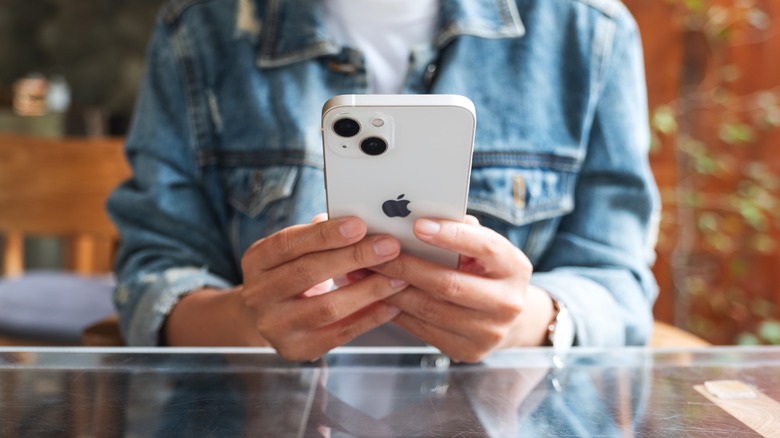 Woman holding the iPhone 13.
