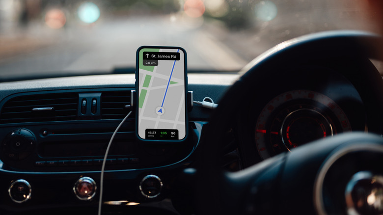 Person looking at a smartphone screen while driving