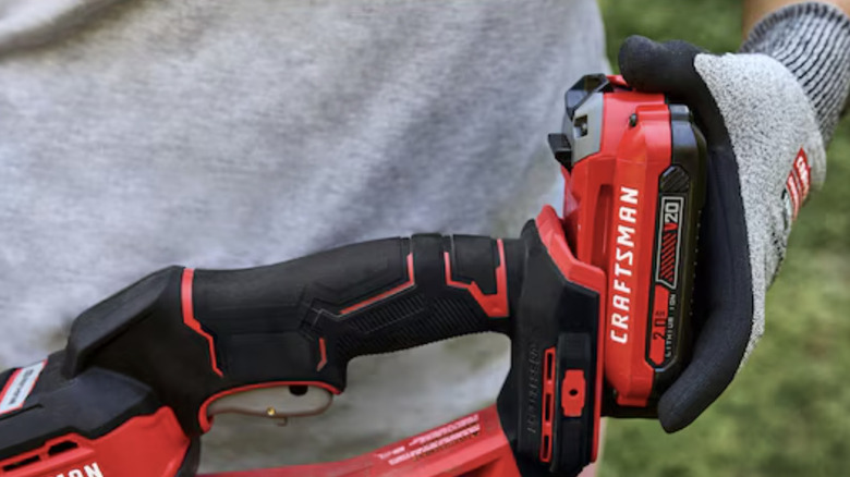 Close-up of a person inserting a Craftsman V20 battery into a power tool