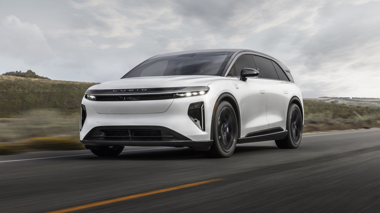 White Lucid Gravity GT-S SUV driving on a desert road.