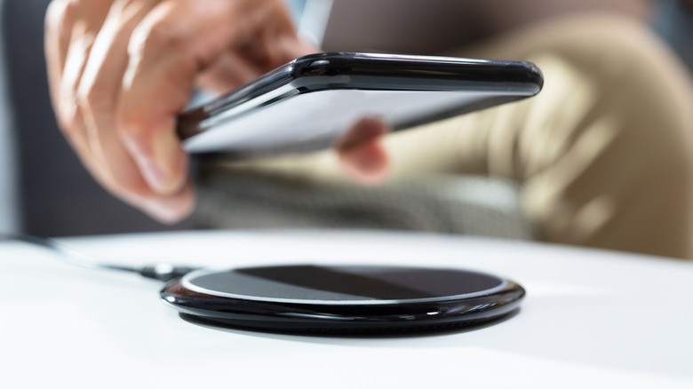 Man placing phone on his wireless charger.