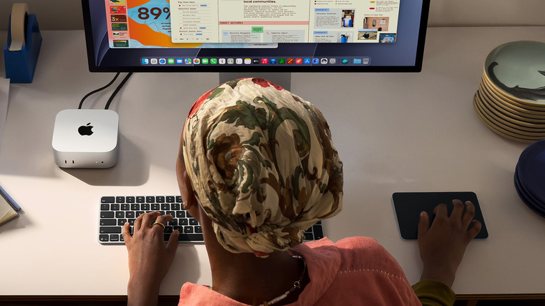 A person using a Mac mini with peripherals