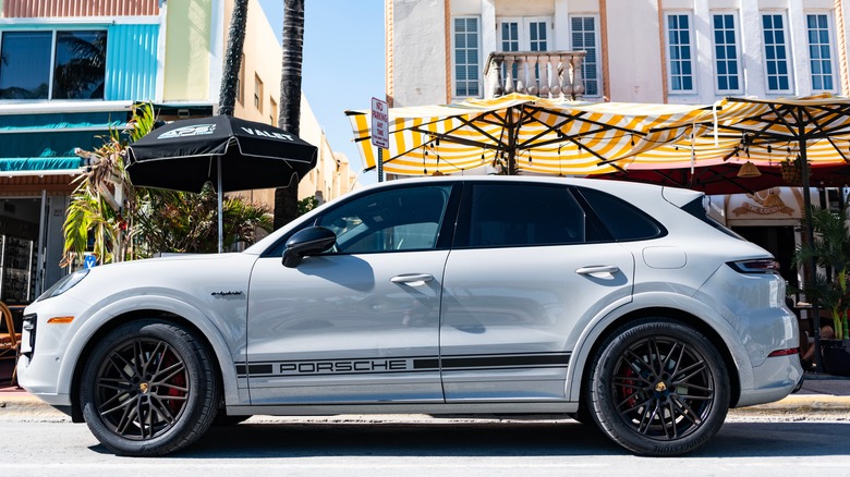 A white Porsche Cayenne parked on a street