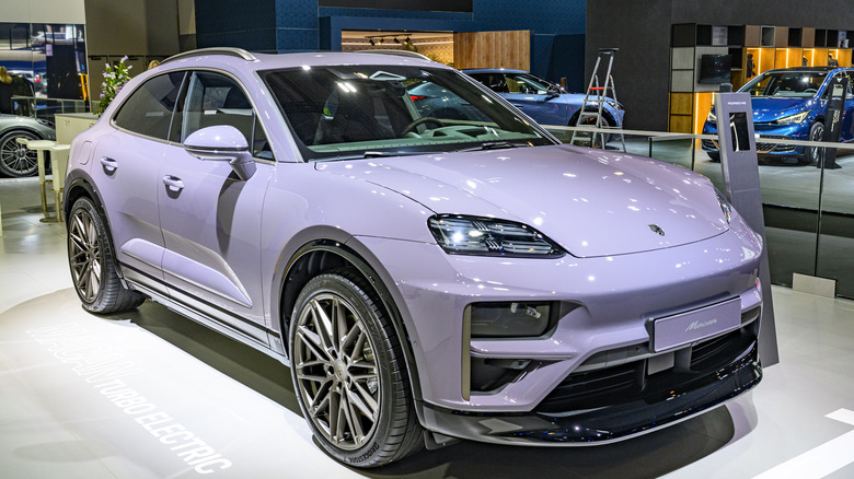 A lavender Porsche Macan on display at an auto show