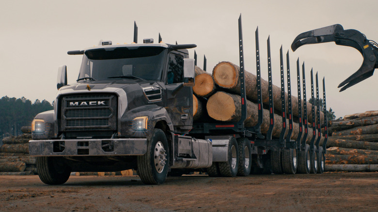 Front 3/4 view of Mack logging truck being loaded with lumber